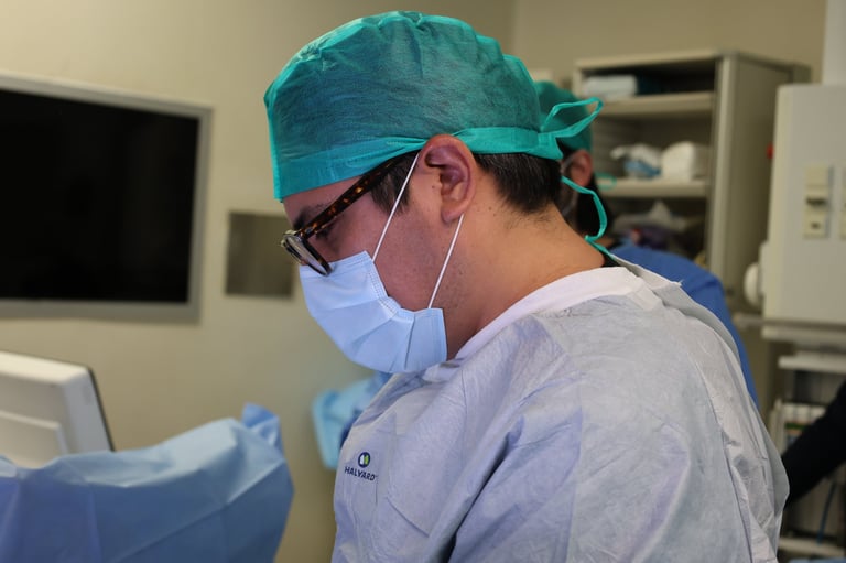 Healthcare professional wearing surgical cap, mask, and glasses in a medical facility